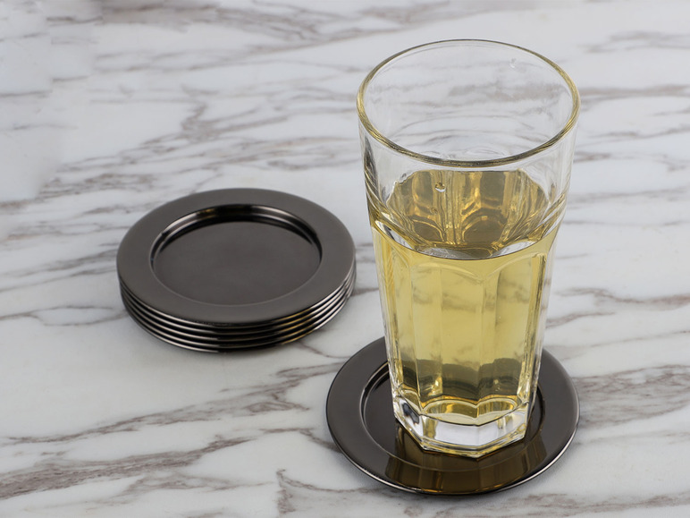Un verre avec une boisson sur un dessous de verre noir.