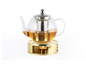 Glazen theepot met thee-infuser op een gouden standaard met een theelichtje.