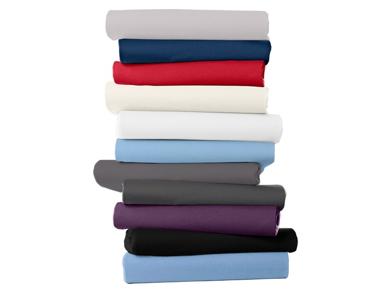 Stapel beddengoed in verschillende kleuren.