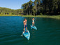 Twee personen die op paddleboards varen in een meer.
