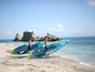 Twee mensen lopen met Aqua Marina stand-up paddleboards op een strand.
