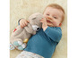Un bébé tenant un doudou Fisher-Price.