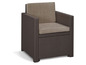 Een bruine wicker stoel met beige kussens.