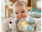 Un bébé tenant un animal en peluche Fisher-Price avec lumière et son.