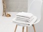 Pile de serviettes blanches sur une chaise blanche