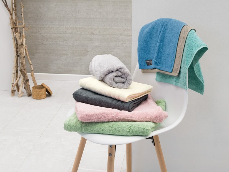 Pile de serviettes de bain et de toilette, y compris une serviette bleue de Kleine Wolke.
