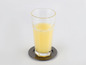 Un verre de jus d'orange sur un dessous-de-verre argenté.