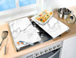 Deux planches à découper en marbre sur une cuisinière à gaz avec un plat allant au four et un couteau.