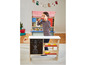 Un enfant joue avec un magasin de jouets en bois avec un tableau noir et des étagères.