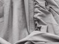 Een close-up van een grijze stretchstof, geschikt voor kleding of beddengoed.