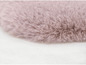 Un tapis en fausse fourrure rose.