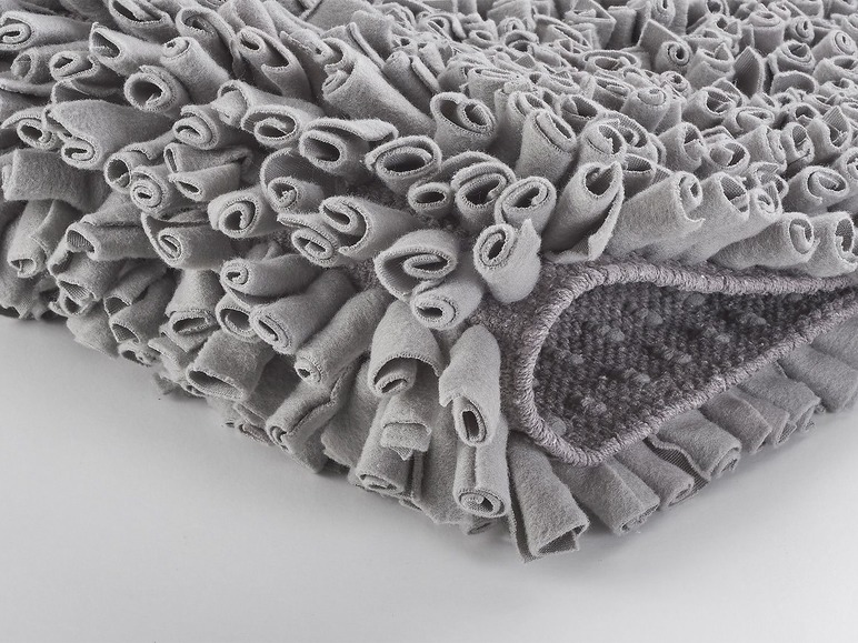 Een grijs vloerkleed met franjes voor honden