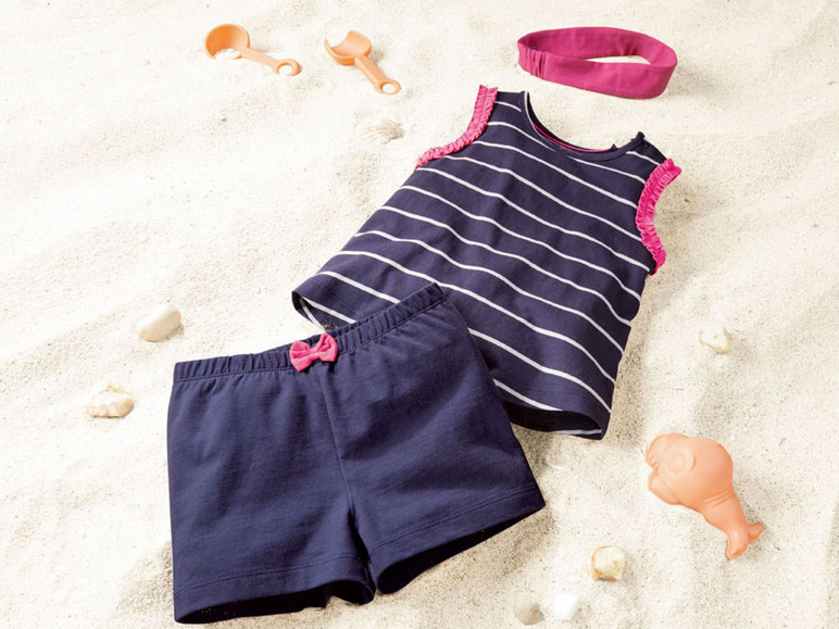 Een gestreept badpak en zwembroek met strikjes op het strand.