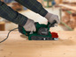 Een persoon gebruikt een Parkside bandschuurmachine op een houten plank.