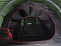 Een groene tent met rode accenten, van binnenuit gefotografeerd.