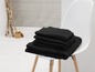 Pile de serviettes noires sur une chaise blanche
