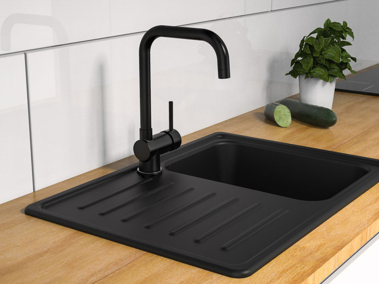 Een zwarte gootsteen met een zwarte kraan in een moderne keuken.