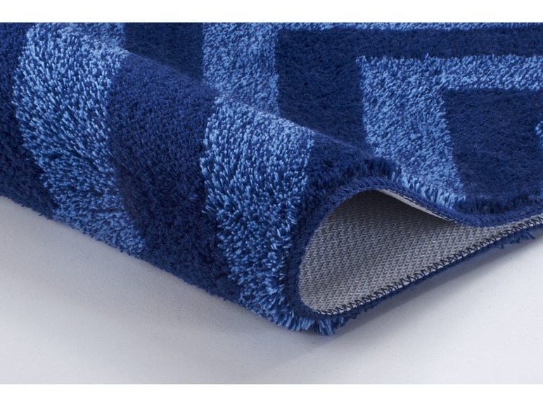 Blauw vloerkleed met chevron patroon.