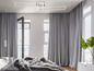 Een moderne slaapkamer met grijze gordijnen, een groot bed en een strakke lamp.