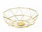 Een gouden metalen fruitschaal in geometrische vorm.
