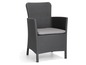 Une chaise en rotin grise avec un coussin gris.
