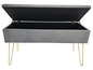 Banc en velours gris avec pieds dorés et espace de rangement.