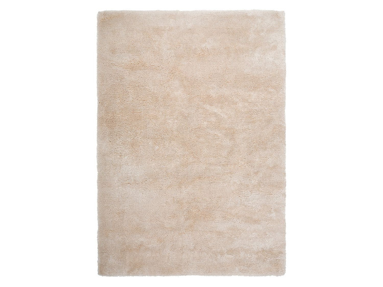 Un tapis beige avec une surface douce et pelucheuse.