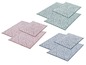 Trois tapis de bain avec un motif géométrique en rose, bleu et vert.