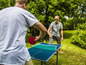 Twee mannen spelen tafeltennis in de tuin.