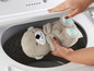 Un ourson en peluche en forme de loutre est placé dans une machine à laver.