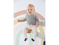 Een baby draagt gestreepte kleding en een broek.