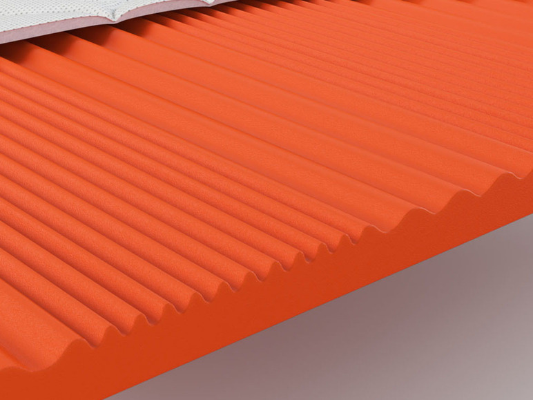 Een oranje schuimmatras met een geribbelde structuur.