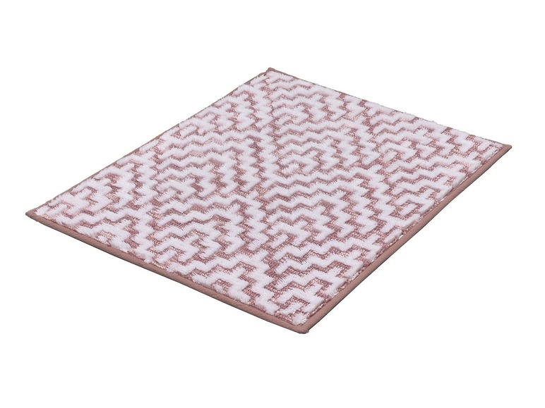Tapis de bain rose avec motif géométrique.