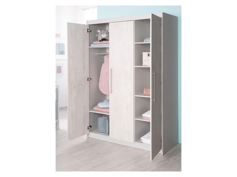 Une armoire blanche avec des portes ouvertes, adaptée à une chambre de bébé.