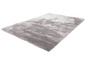 Un tapis gris, doux avec un design uni et nuageux.