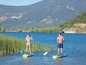 Twee personen op paddleboards, peddelen op een meer.