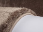Gros plan sur un tapis beige avec une bordure brossée.