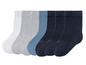 Zeven paar sokken in wit, grijs, blauw en donkerblauw.