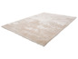 Un tapis beige clair avec une surface douce et moelleuse.