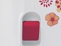 Une bouilloire blanche avec un bouton rouge et un motif floral.