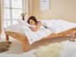 Une femme dans un lit avec une couette et un oreiller de la marque 