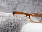 Un tapis en fourrure grise avec des lunettes brunes.