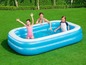 Une famille s'amuse dans une piscine gonflable dans le jardin.