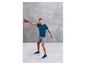 Homme en vêtements de sport avec une kettlebell rouge pendant un entraînement.