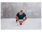Un homme fait des pompes avec une kettlebell rouge.
