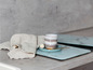 Une tasse sur un dessous de plat en verre avec un motif marbré, un torchon et une cuillère