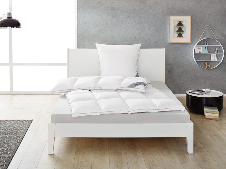 Un lit blanc avec une couette et un oreiller de la marque 
