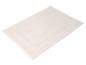 Un tapis de bain crème avec un bord brodé.