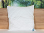 Un oreiller blanc Beco sur un lit.