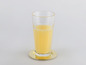 Un verre de jus d'orange sur un sous-verre doré.